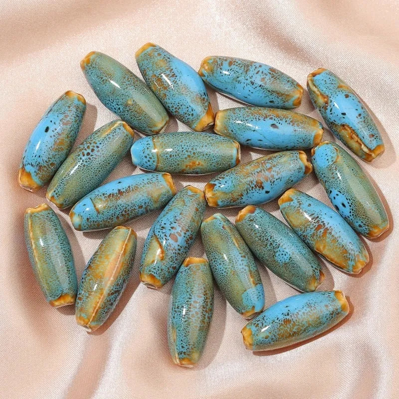 Assorted high-temperature fired ceramic bullet beads in pink, yellow, blue, red, coffee, green, orange, and mixed glaze colours.