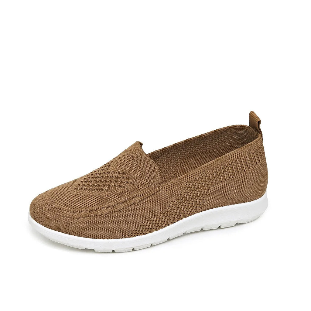 Women's beige canvas flat shoes with a heart pattern, mesh lining, and a flat rubber sole.
