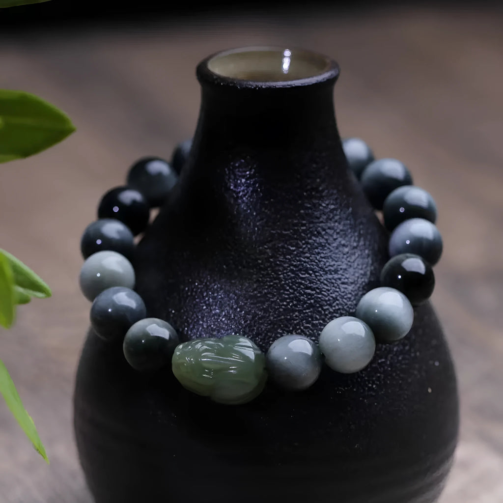 Black bracelet with 10mm Eagle Eye stone beads and a Hetian Jade Pixiu charm.