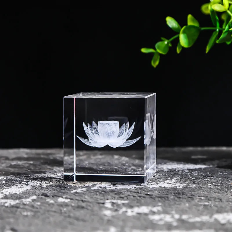 White crystal square ornament with engraved lotus design on a desk surface