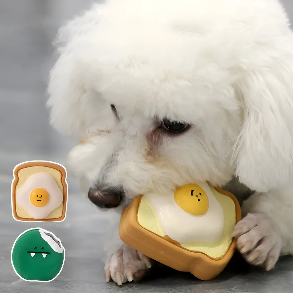 Green and yellow latex dog chew toy shaped like cartoon egg bread with a squeaker.