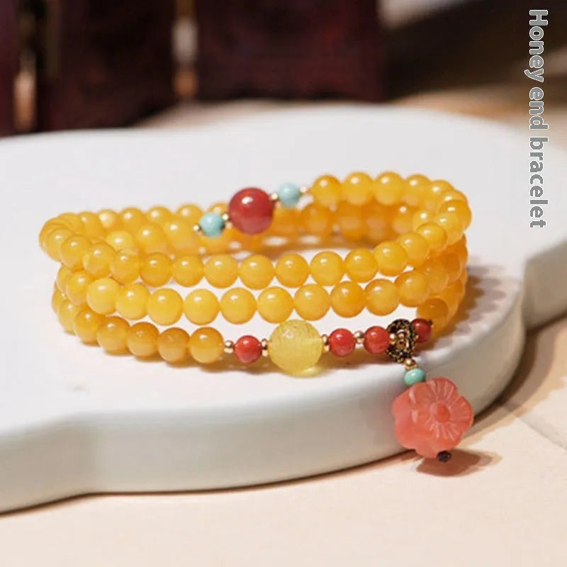 Close-up of a women's amber bracelet with animal modelling on round 5mm beads.
