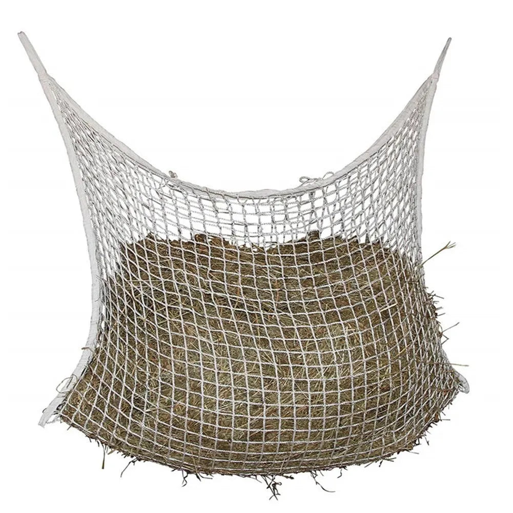 Woven polyethylene rope horse feeding bag in black hanging with hay visible through grid
