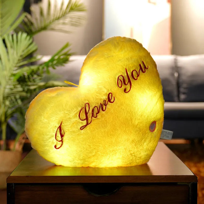 Colourful glowing five-pointed star plush pillow on a dark background, showing soft texture and LED illumination