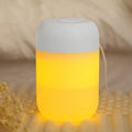 White cylindrical mini humidifier with USB cable on a wooden surface.