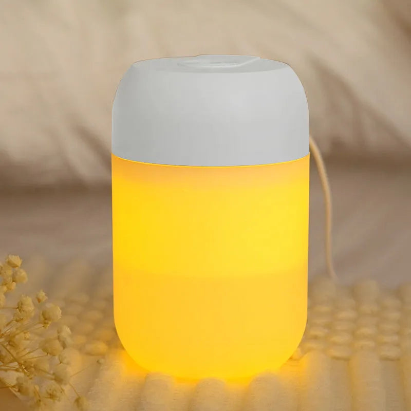 White cylindrical mini humidifier with USB cable on a wooden surface.