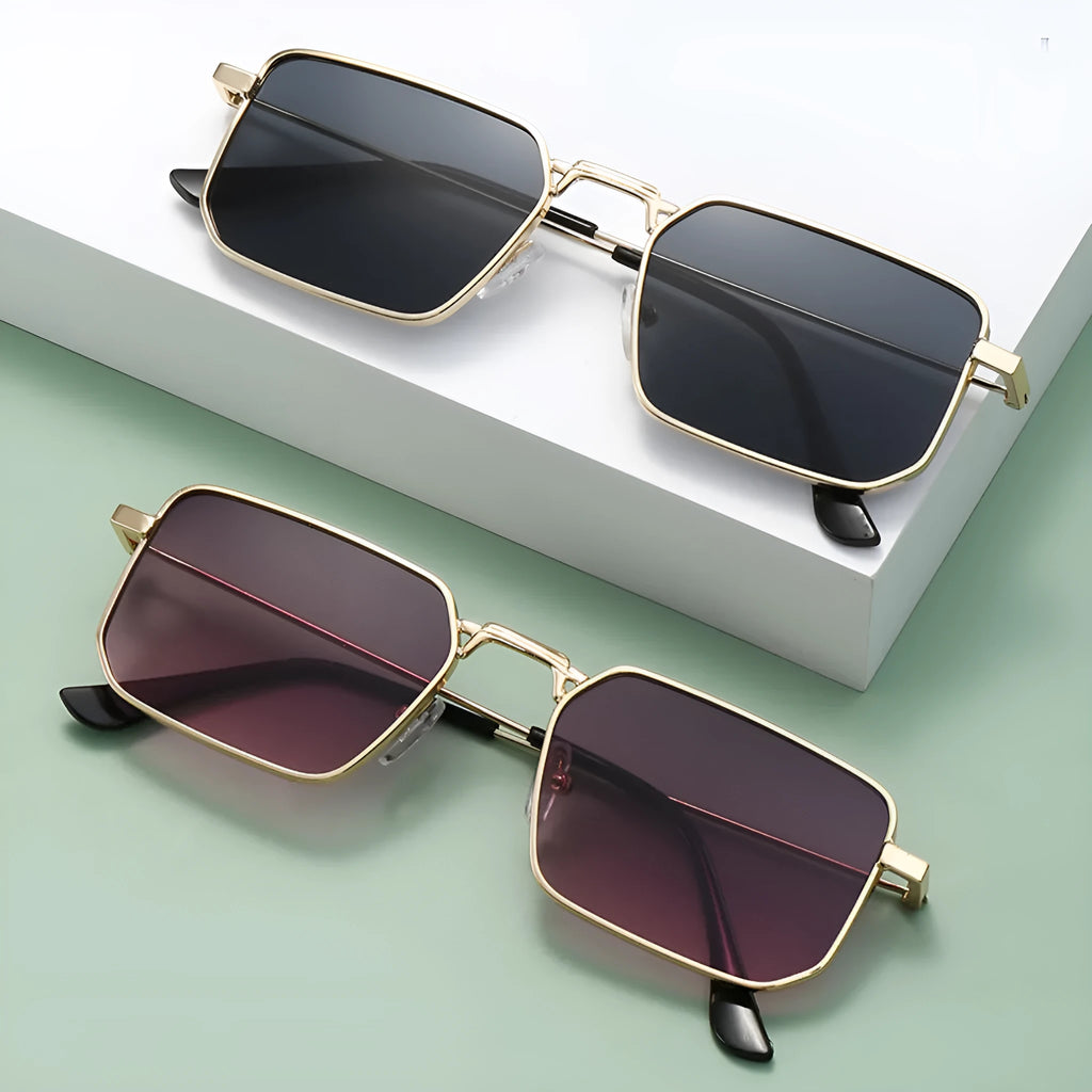 Square-shaped steampunk sunglasses for men with gold frame and grey lenses on a plain background
