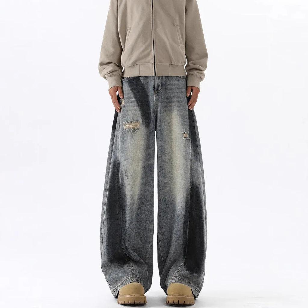 Blue men's loose fit jeans featuring a splash-ink pattern and ripped knee detailing.
