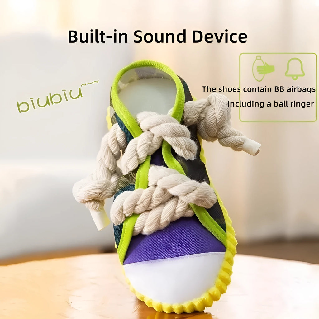 Grey and white dog toy slipper with black laces, blue sole, and a bell on the side