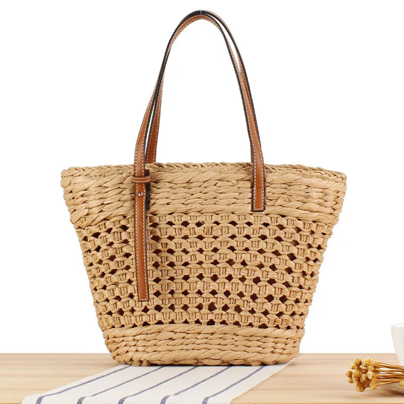 Beige horizontal square woven paper-string shoulder bag showing wide opening and adjustable strap