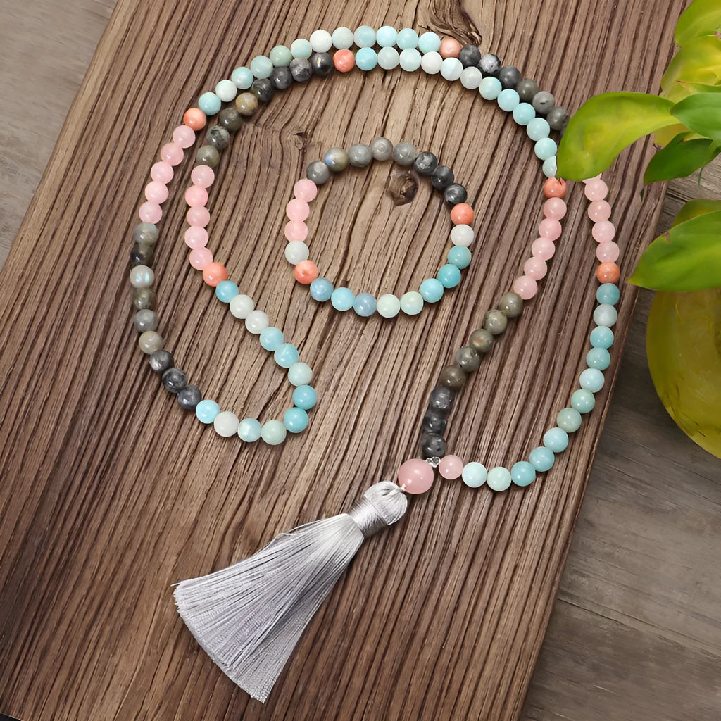 Bohemian style necklace and bracelet set with colourful drop-shaped stone pendants and tassel details on a white background