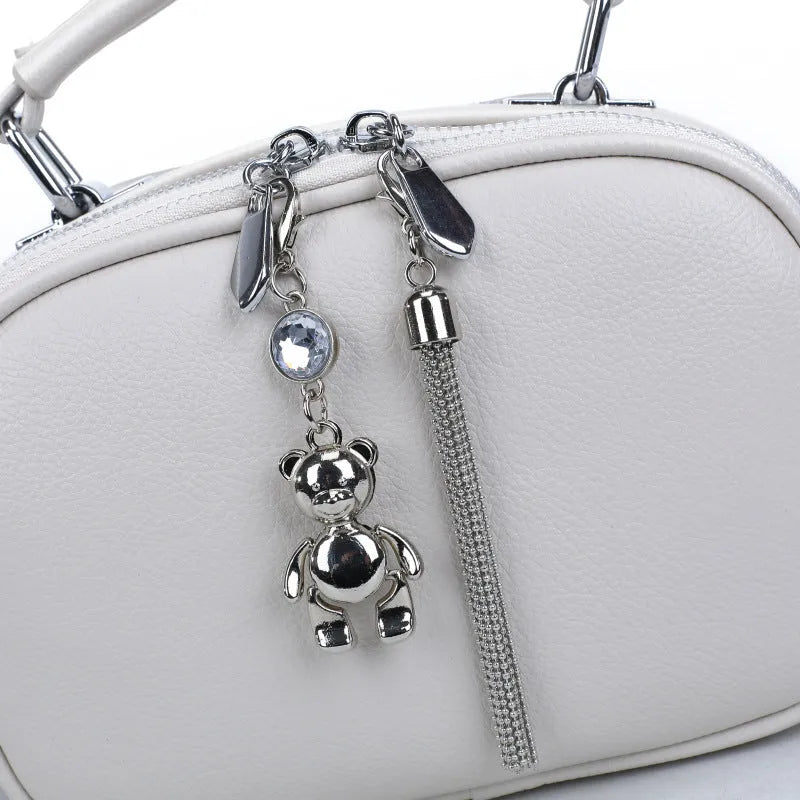 Oval-shaped women's small square handbag in PU with stitching detail and double straps.