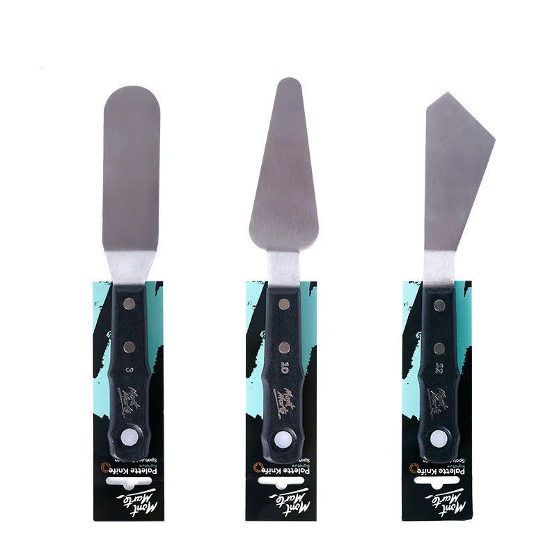 Three stainless steel painting palette knives with different blade shapes on artist's palette