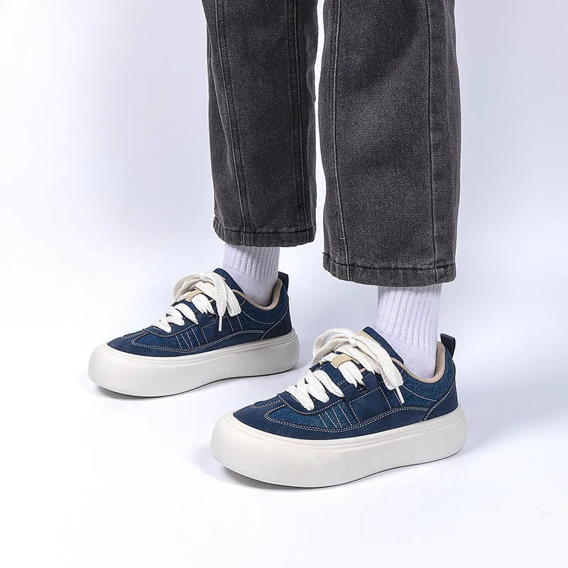 Men's black canvas platform sneakers with round toe and lace-up front on grey background