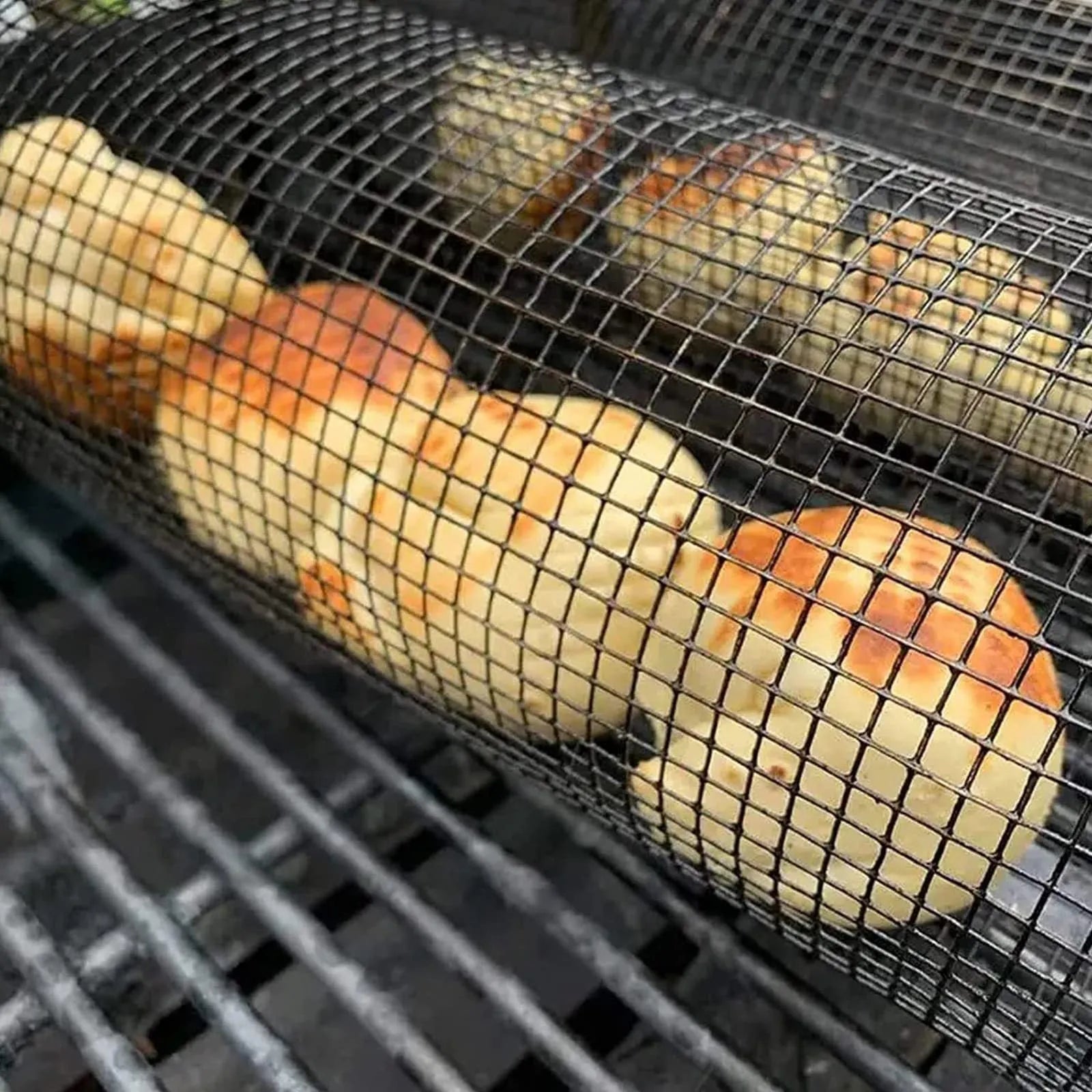 A cylindrical iron wire mesh rolling barbecue basket with a metal hook for handling.