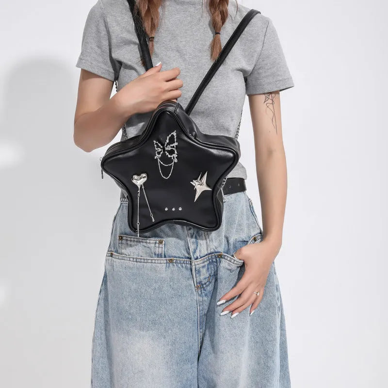 Black soft PU street-style backpack with metal star and butterfly pendants, chain trim, and multiple pockets.