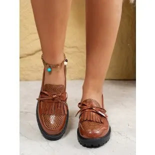 Women's black loafers with a decorative bow detail on the upper.
