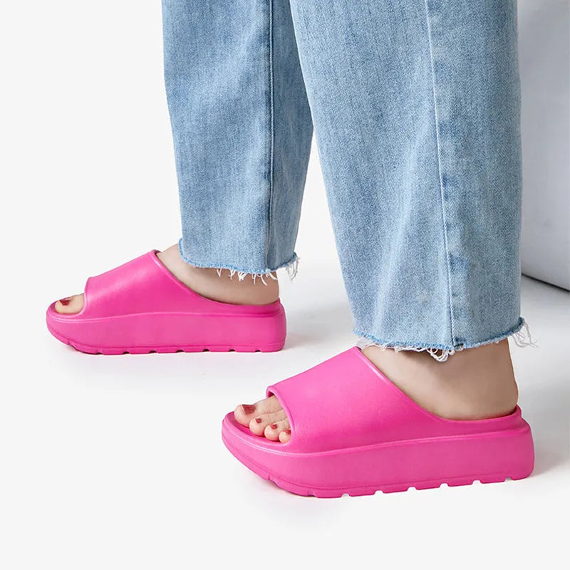 Women's beige fish mouth slippers with a thick EVA sole on a bathroom tile floor.