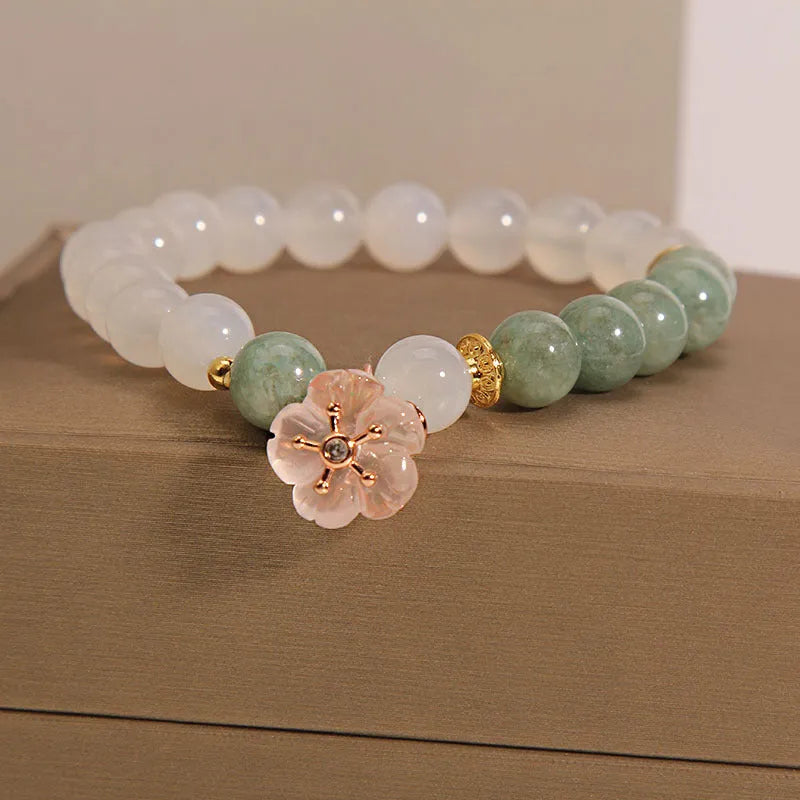 White agate jade bracelet with floral shape on a casual model wrist.