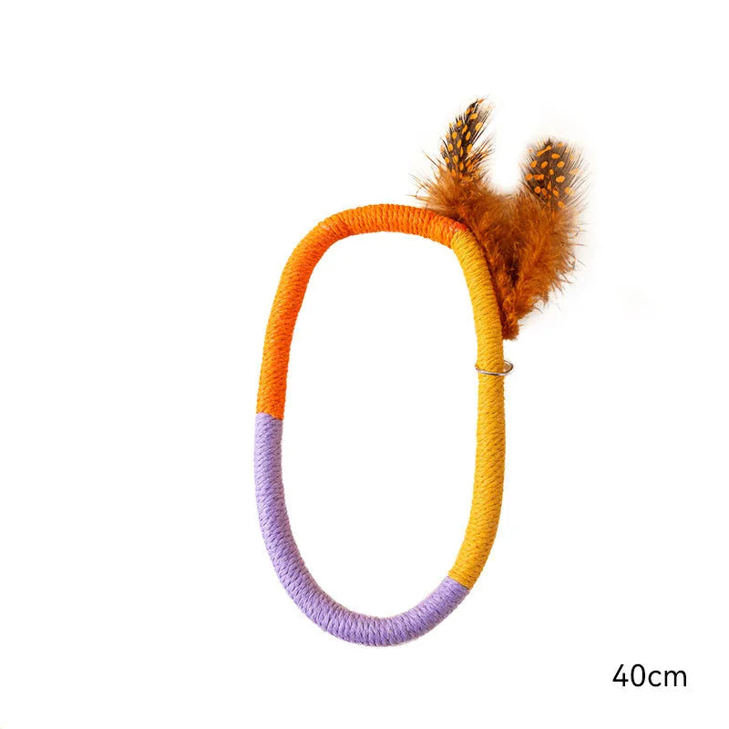 Green circular cotton rope cat toy with feathers attached, shown next to purple version