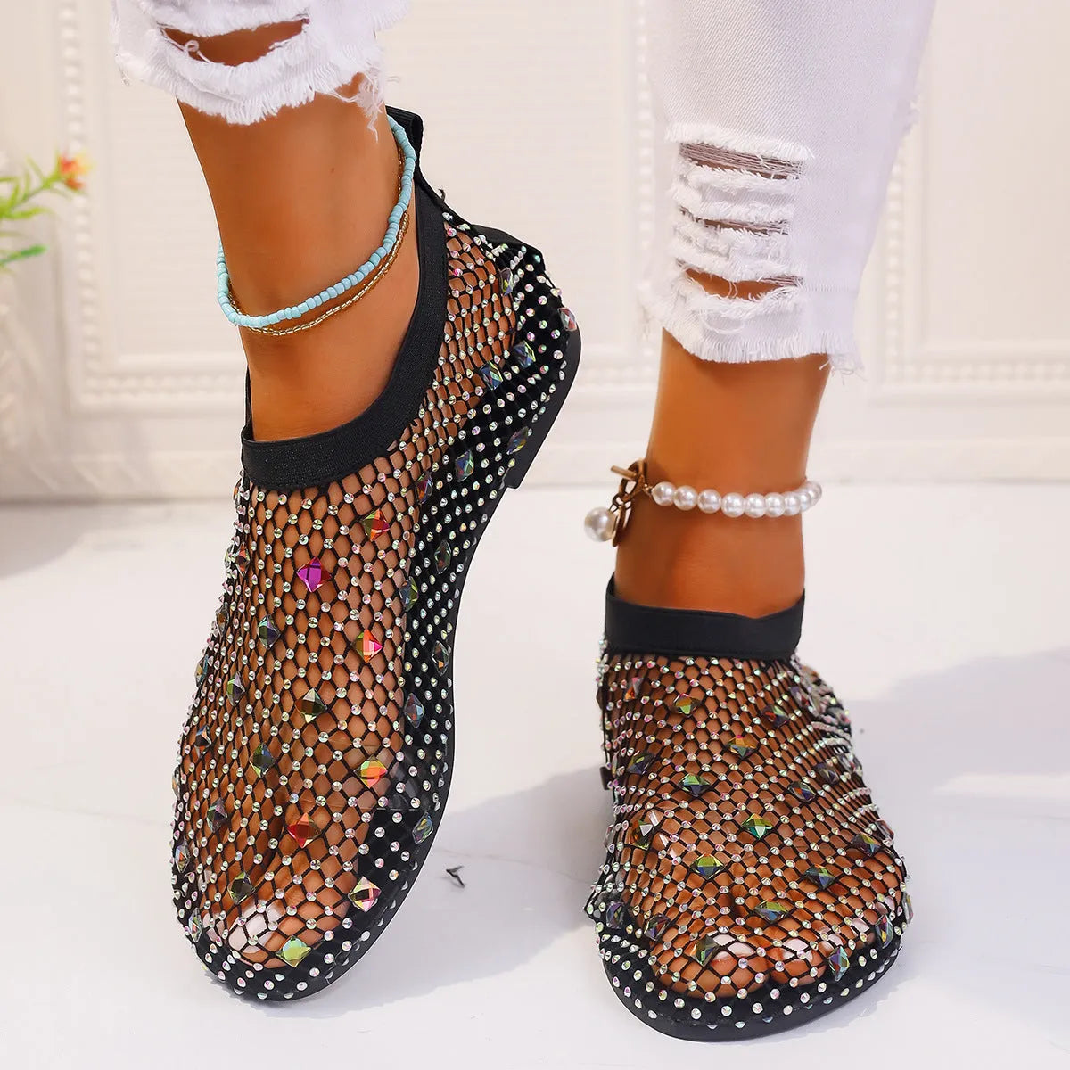 Women's flat mesh sandals with colourful rhinestone detail on a white background.
