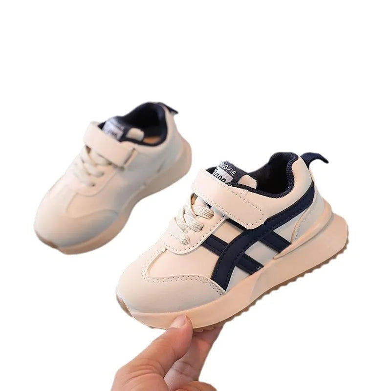 Children's white casual sneaker with Velcro strap, synthetic leather upper, and rubber sole on a neutral background.