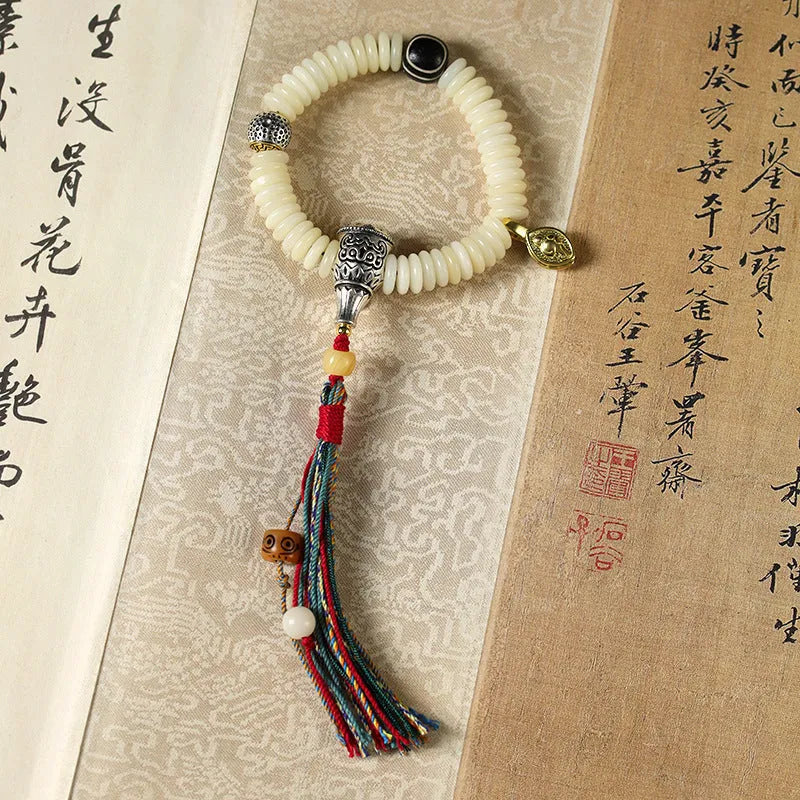 Close-up of a White Bodhi seed bracelet showing its 3x10mm beads and string.