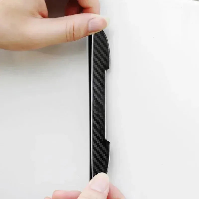 Black carbon fibre texture car door edge guard strips laid out, showing universal fit design.
