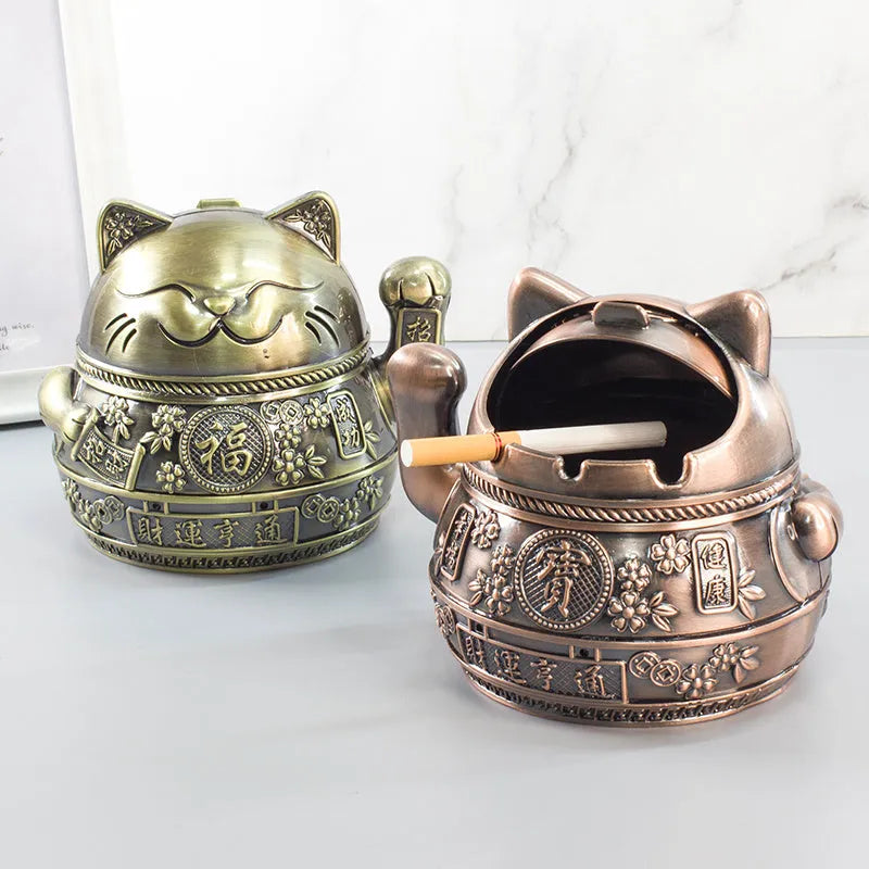 Zinc alloy lucky cat ashtray with cover in gold black colour on a wooden table