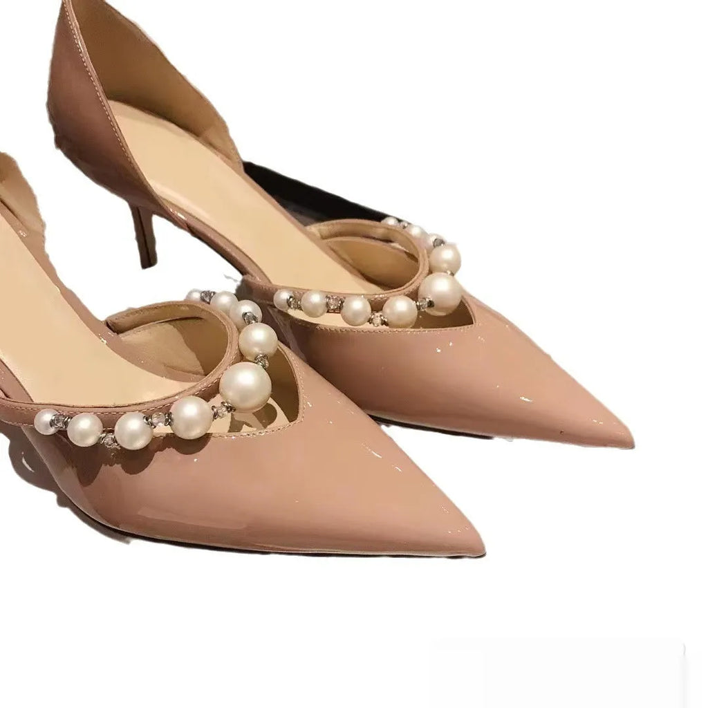 Women's pointed patent leather stiletto high heels with pearl detail on the heel.