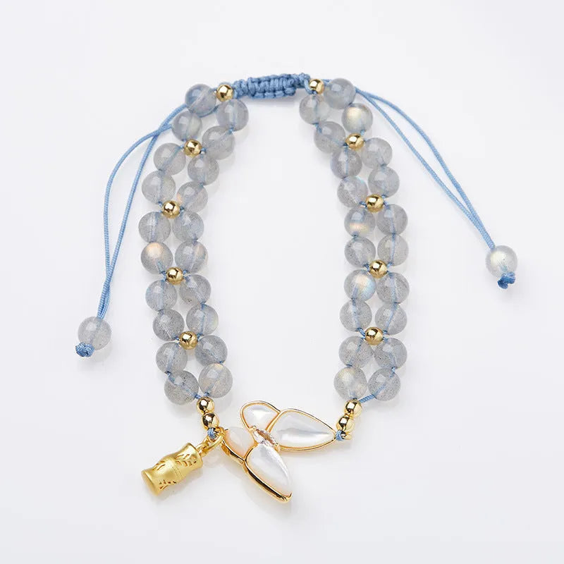 Grey moonstone butterfly charm on a handwoven cord bracelet for women.