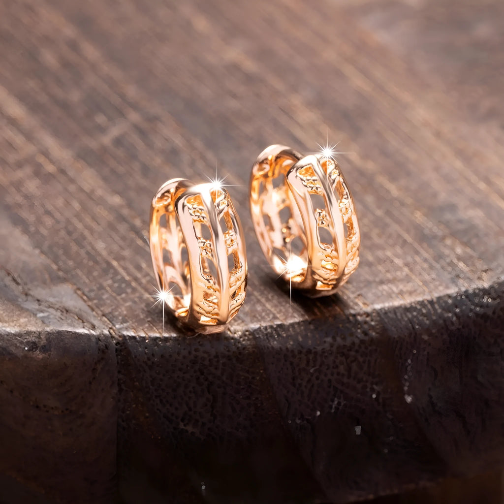 Close-up of rose gold hollowed-out heart and leaf drop earrings showing intricate open metalwork and 2.8cm length.