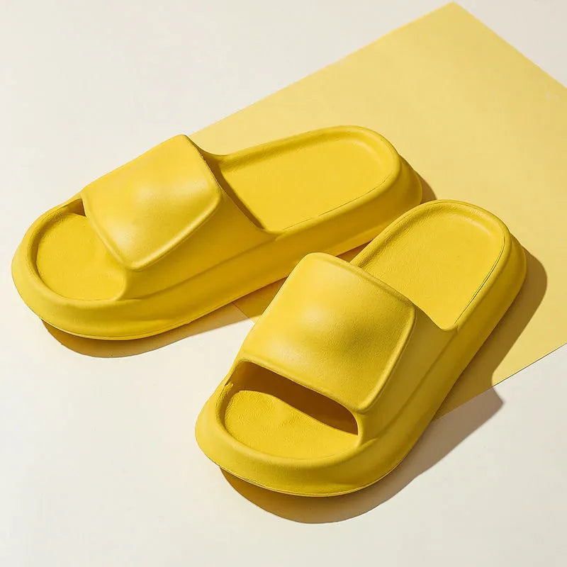 Pair of white EVA flip-flop slippers with a thick, textured sole on a tiled floor.