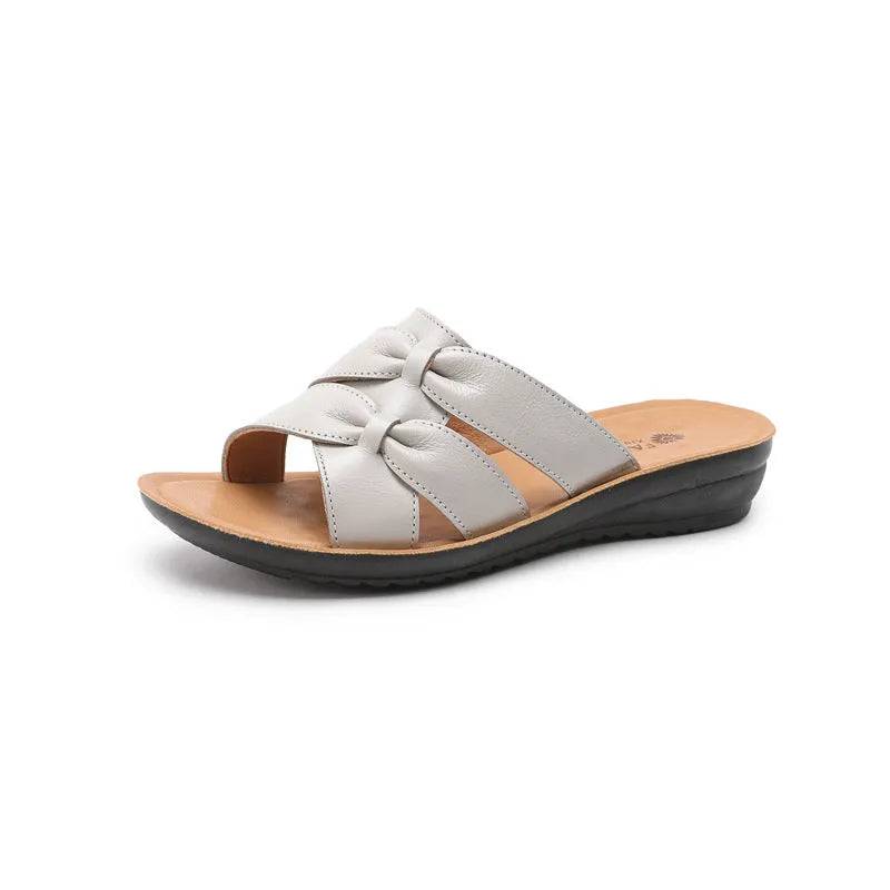 Beige cowhide women's slipper sandals with a non-slip sole, shown from the side.