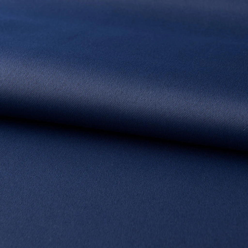Dark navy blue blackout curtain hanging, showing its modern simple style and light-blocking fabric.