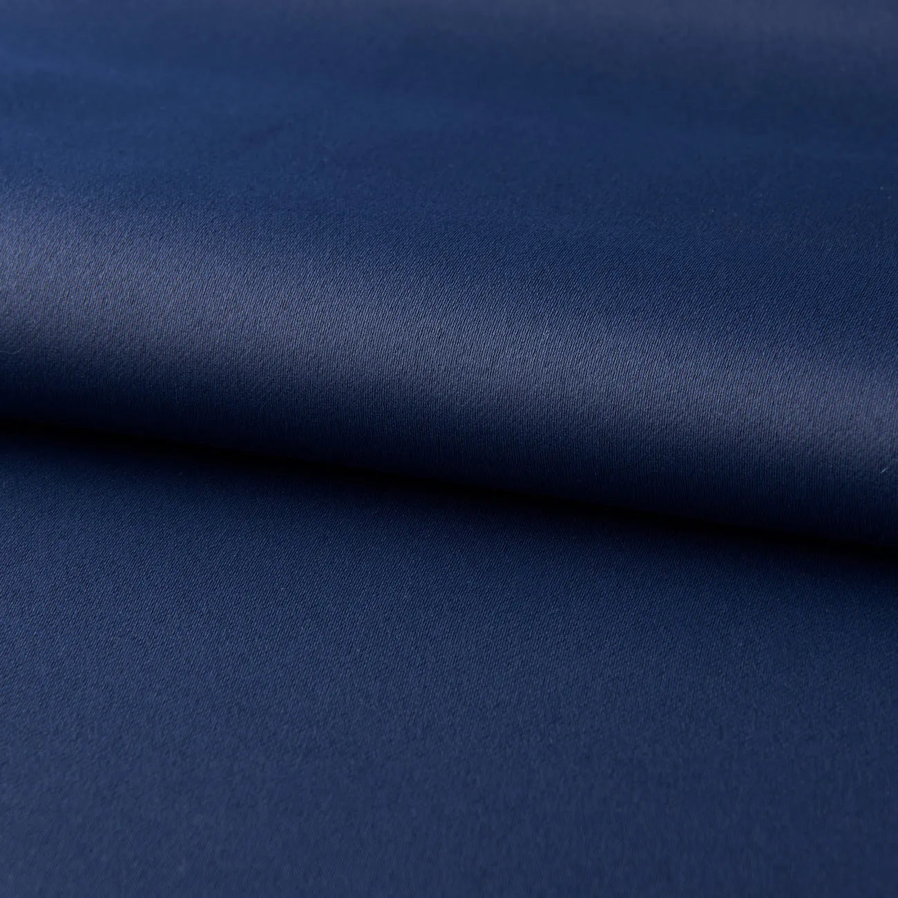 Dark navy blue blackout curtain hanging, showing its modern simple style and light-blocking fabric.