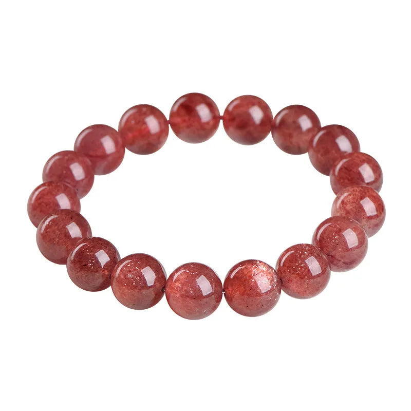 Cherry red strawberry quartz crystal bracelet with geometric beads on a wrist.