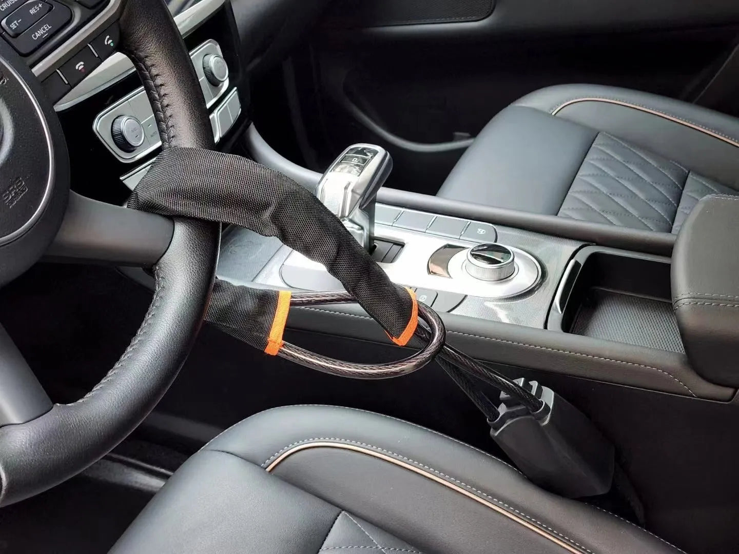 Red iron wire rope steering wheel lock for General Motors cars on a steering wheel.