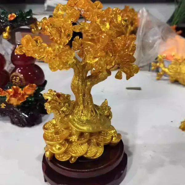 Citrine-coloured resin Feng Shui ornament of a small water turtle money tree on a white background.