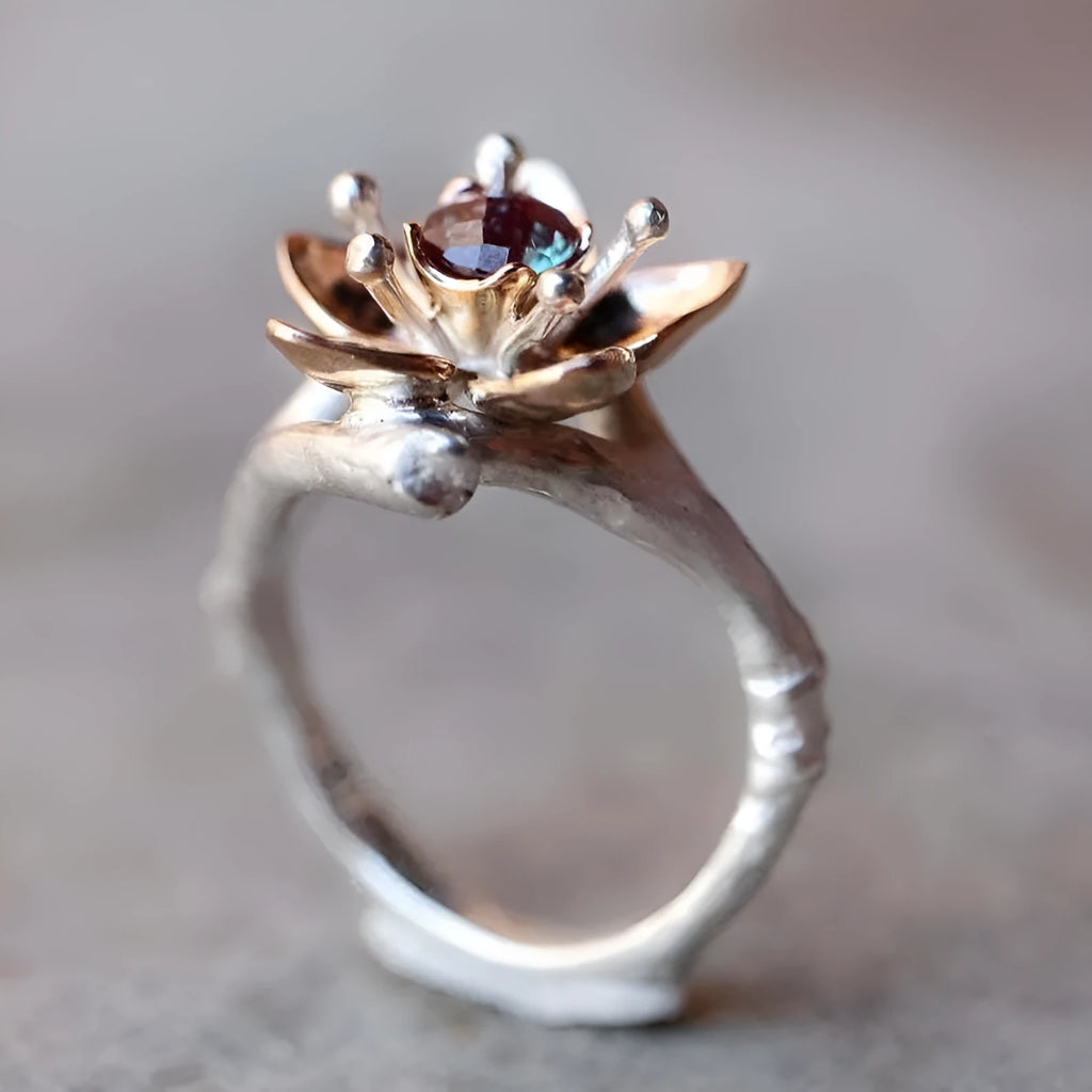 Silver two-tone alloy ring with a geometric floral pattern on a model's hand.