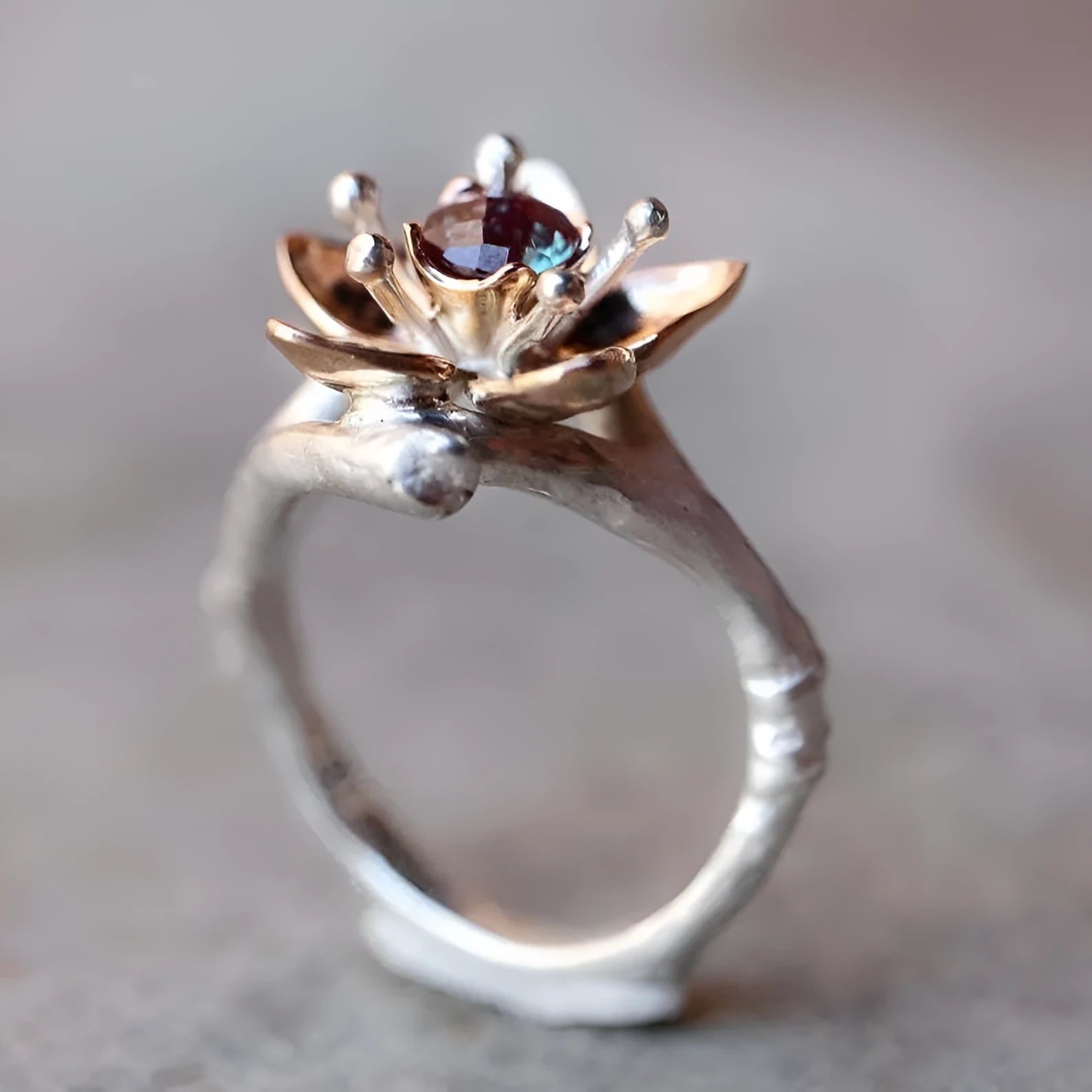 Silver two-tone alloy ring with a geometric floral pattern on a model's hand.