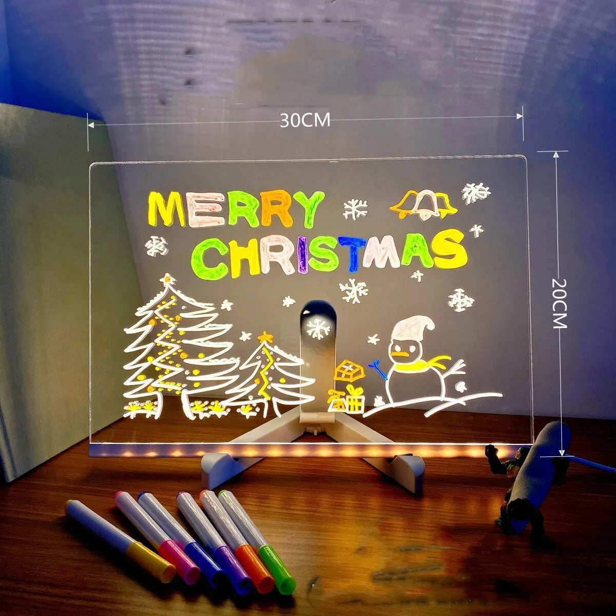 Acrylic DIY LED message board on a bracket, glowing softly with handwritten notes, alongside white and colourful pens.