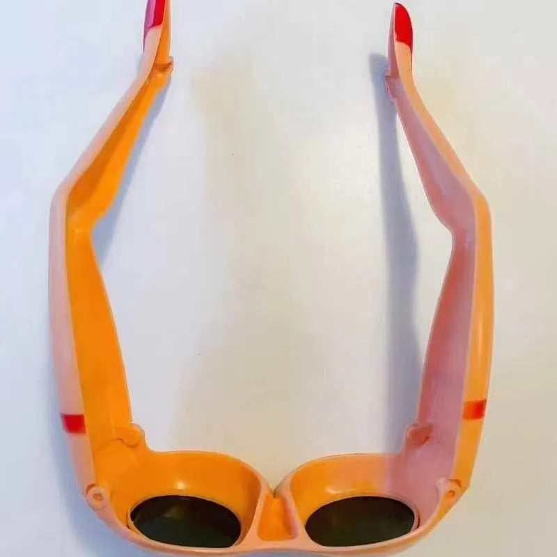 Orange plastic sunglasses with wide lenses on a white background, showing adjustable leg hip design.