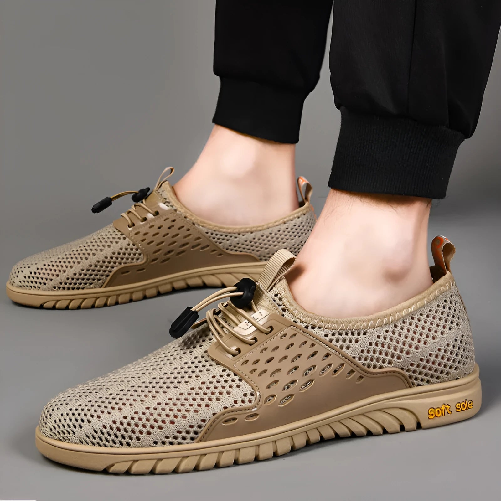 Men's breathable casual shoes in black with mesh upper, elastic band closure, and rubber sole