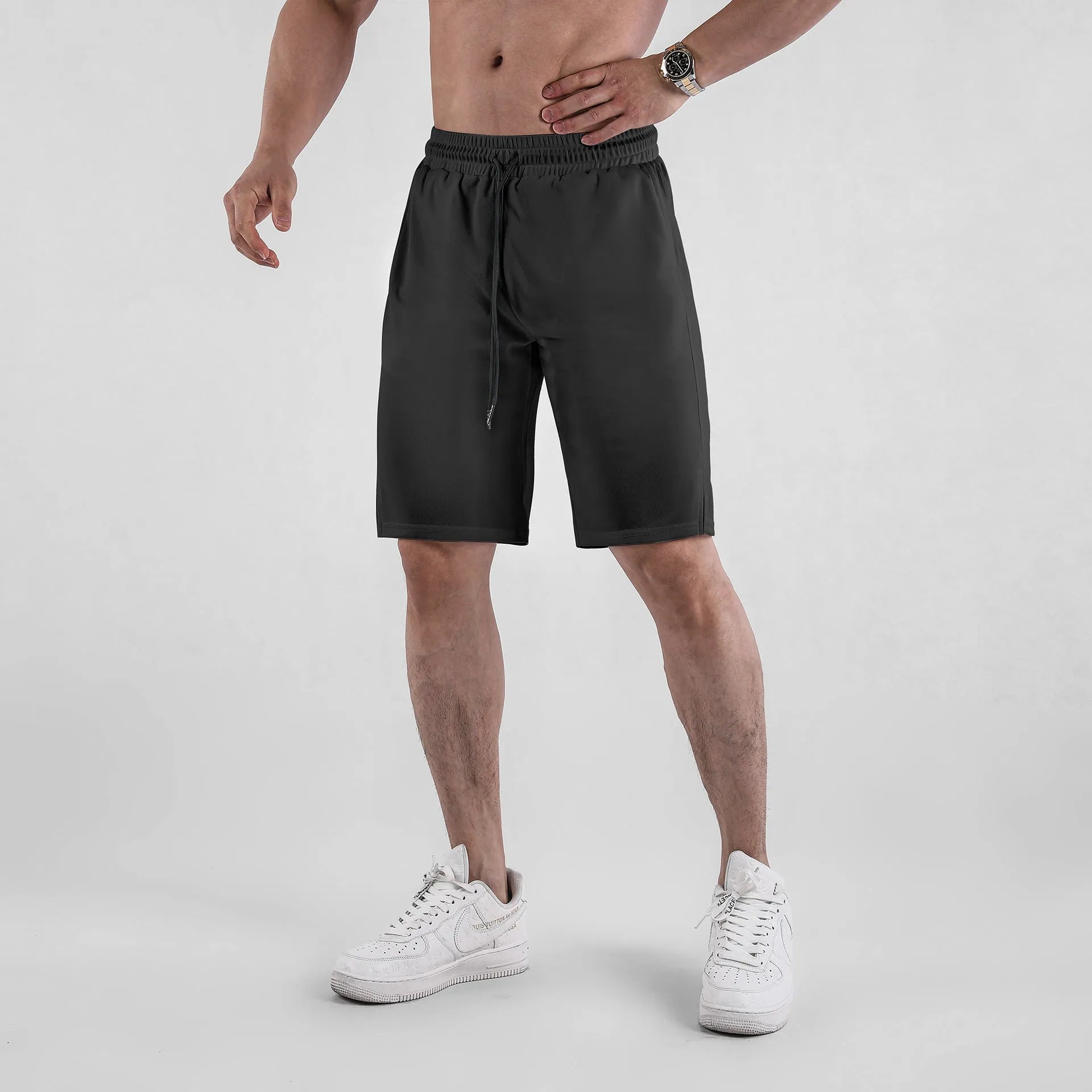Man wearing black quick-drying mesh fitness shorts with elastic waistband
