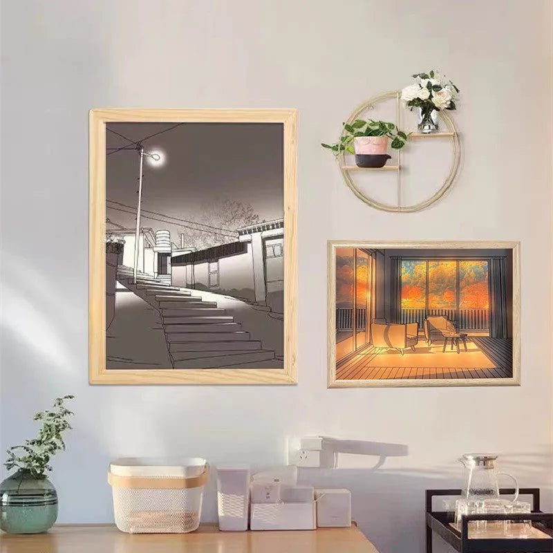 LED illuminated decorative picture light on a bedside table showing a sunny landscape scene.