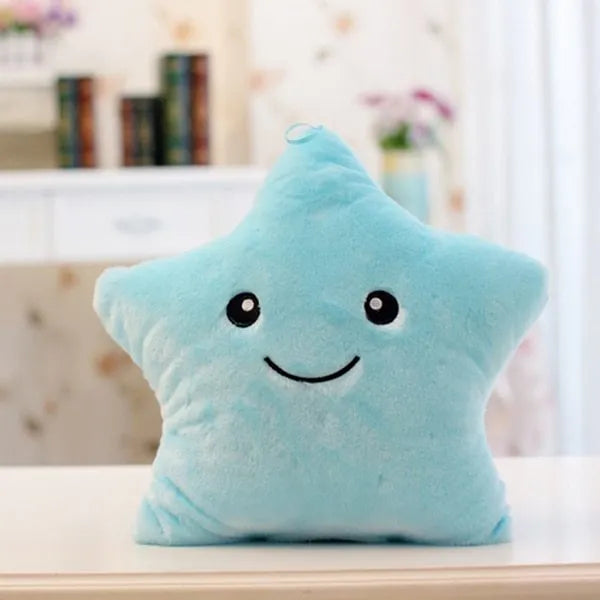 Colourful glowing five-pointed star plush pillow on a dark background, showing soft texture and LED illumination