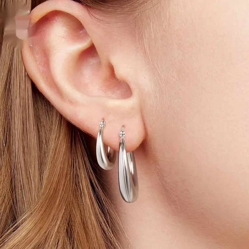 A pair of copper geometric ring ear clips with a silver needle, shown in large, medium, and small sizes.