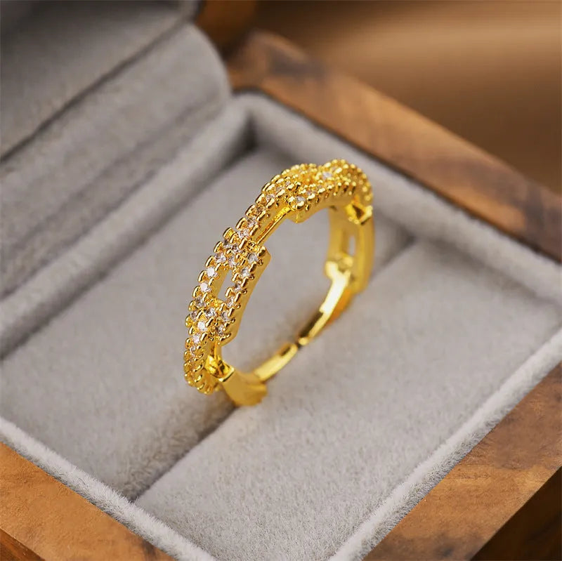 Gold-toned open-ended geometric women's ring on a neutral background, showing adjustable design.