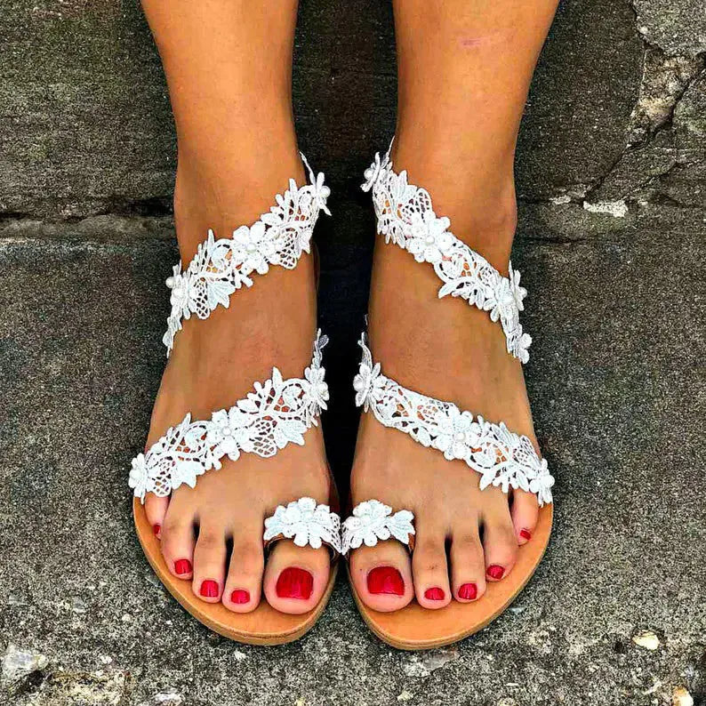 White women's flat sandals with rhinestone floral detail on artificial PU upper